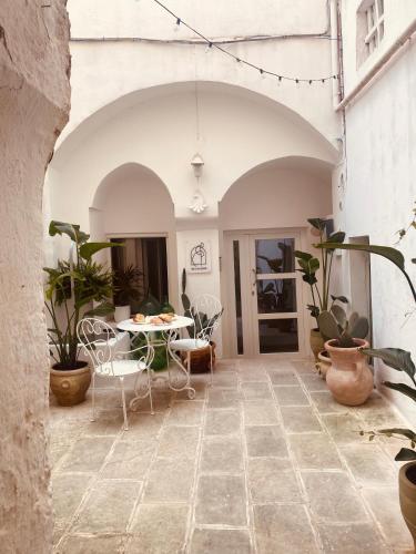 a patio with a table and chairs and potted plants at Corte San Giorgio in Matino