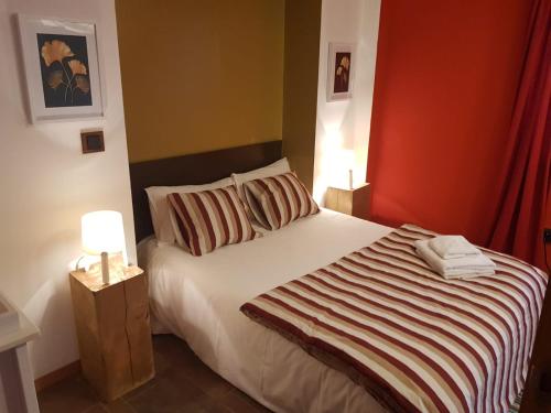 a bedroom with a white bed with a red wall at Casa Rural El Quintanarejo in Vinuesa