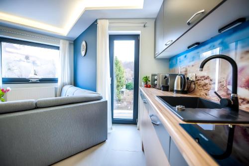 een keuken met blauwe muren, een wastafel en een bank bij Baltic Haus in Gdańsk