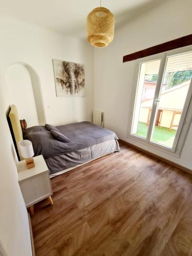 une chambre avec un lit et une grande fenêtre dans l'établissement Appart hôtel plage des capucins, à La Ciotat