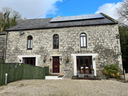 una casa in pietra con pannelli solari sul tetto di The Chapel Guest House a St Austell