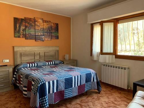 ein Schlafzimmer mit einem Bett mit einer blau-weißen Decke in der Unterkunft Apartamento Rural Lago Ercina in Cangas de Onís