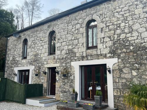 ein Steingebäude mit schwarzen Türen und Fenstern in der Unterkunft The Chapel Guest House in St Austell