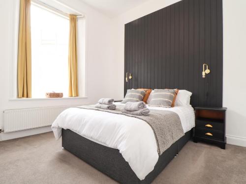 a bedroom with a large bed with a black headboard at 1 Regents Mews in Penzance