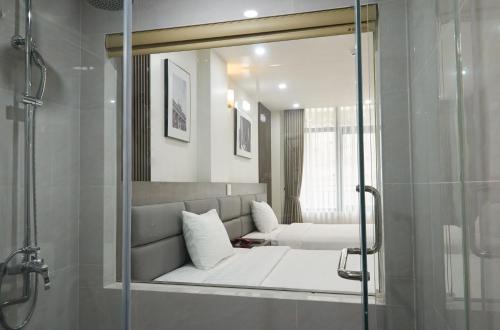 um quarto com uma cama e um espelho na casa de banho em Van Nam Hotel em Ha Long