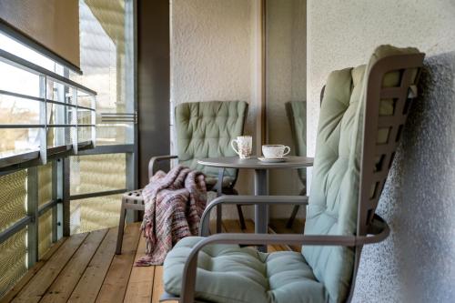 a room with a table and chairs on a balcony at Hotel FrechDachs in Bad Füssing