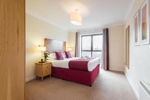 um quarto de hotel com uma cama e uma janela em PREMIER SUITES Bristol Redcliffe em Bristol