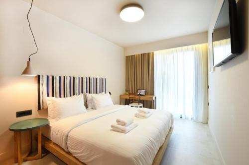 a bedroom with a bed with towels on it at Pavo Art Hotel in Heraklio Town