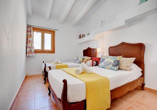 two beds in a room with white walls at Alvaro Oliver House by Slow Villas in Porto Cristo