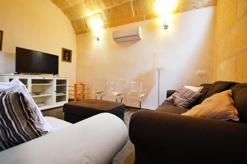 uma sala de estar com um sofá e uma televisão de ecrã plano em Amilcar House by Slow Villas em El Arenal