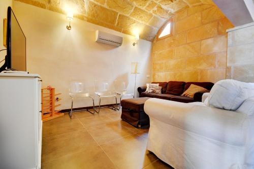 uma sala de estar com um sofá e algumas cadeiras em Amilcar House by Slow Villas em El Arenal