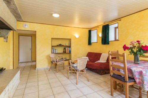 ein Wohnzimmer mit einem Sofa und einem Tisch in der Unterkunft Gîte à Confracourt in Confracourt