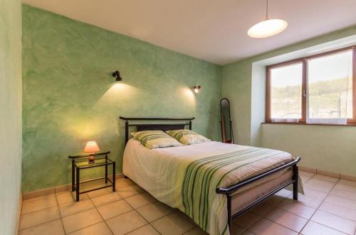sypialnia z łóżkiem i zieloną ścianą w obiekcie Gîte à Confracourt w mieście Confracourt
