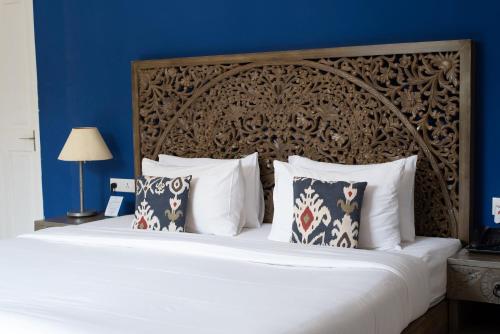 1 dormitorio con 1 cama grande con almohadas blancas en Living Room Beach Resort, en Morjim