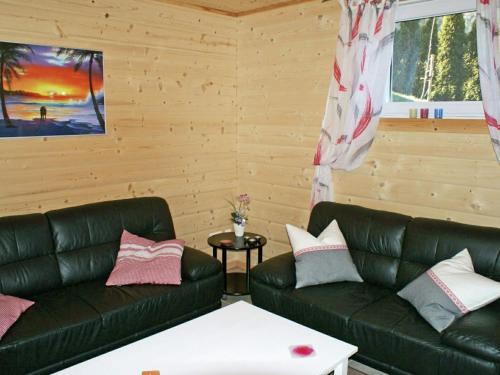 ウムハウゼンにあるApartment in Umhausen near the ski areaのリビングルーム(黒い革張りのソファ2台、テーブル付)