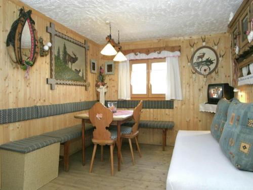 een kamer met een tafel en stoelen en een bed bij Chalet in caroles with a nearby forest in Karrösten
