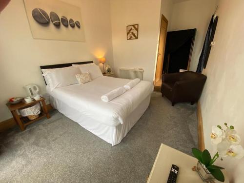 a bedroom with a large white bed and a chair at OYO The Old Mill in Yarm