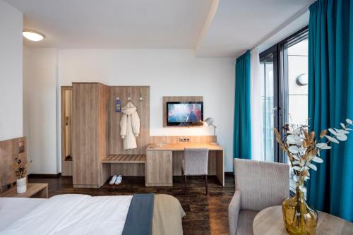 a bedroom with a bed and a desk and a table at KONCEPT HOTEL Benedikt in Siegburg