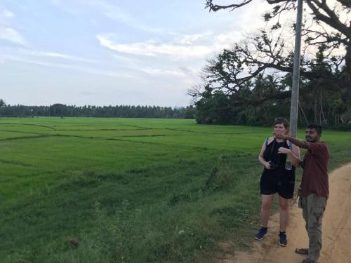 two men standing on a dirt road flying a kite at Elegant Lake Yala Safari House in Tissamaharama