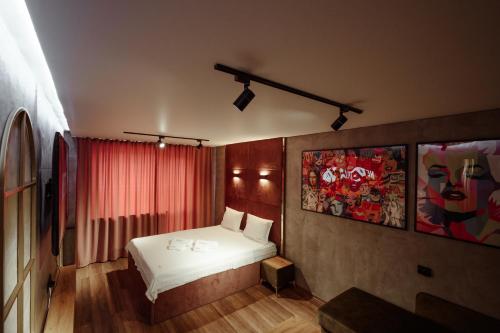 a bedroom with a white bed and a red curtain at Квартира в центре Чаплин in Petropavlovsk