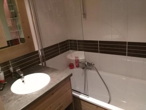 Un baño con lavabo, ducha y bañera. en RISOUL 1850, en Risoul