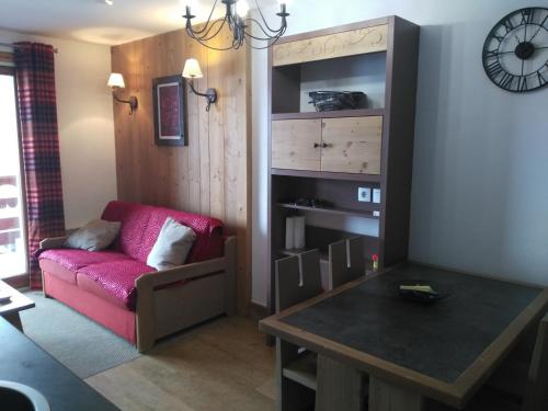 un salon avec un canapé rouge et une table dans l'établissement RISOUL 1850, à Risoul