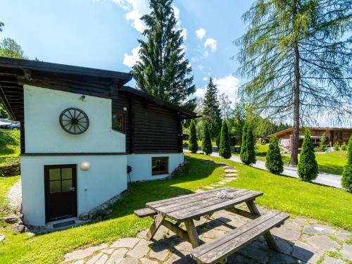 a picnic table in front of a cabin at Cosy chalet in Tyrol with a private garden in Hopfgarten im Brixental