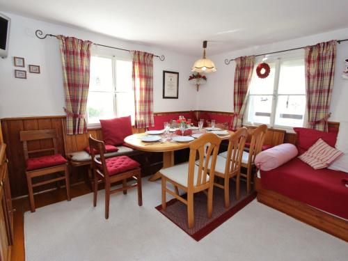 a dining room with a table and chairs and a couch at Austrian chalet in Bramberg with sauna in Bramberg am Wildkogel