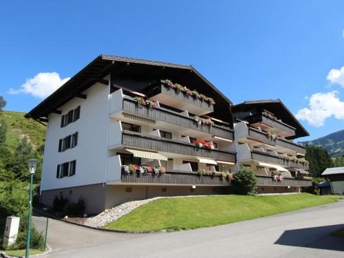 ein großes weißes Gebäude mit Menschen auf Balkonen in der Unterkunft Apartment in Maria Alm directly on the ski slopes in Maria Alm am Steinernen Meer