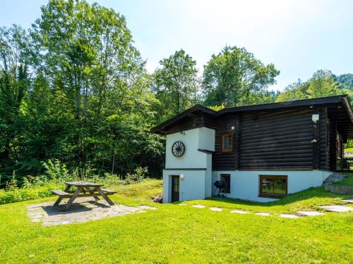 a picnic table in front of a cabin at Cosy chalet in Tyrol with a private garden in Hopfgarten im Brixental