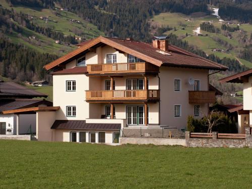 una casa en una colina con un campo verde en Apartment in Westendorf Tyrol with terrace, en Westendorf
