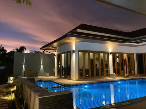 a villa with a swimming pool at night at Banburi Villa - 5 Bedroom Private Pool Villa in Krabi