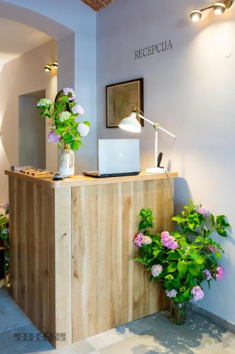a desk with a laptop and flowers on it at Dvorec Gregorčič in Smarjeske Toplice
