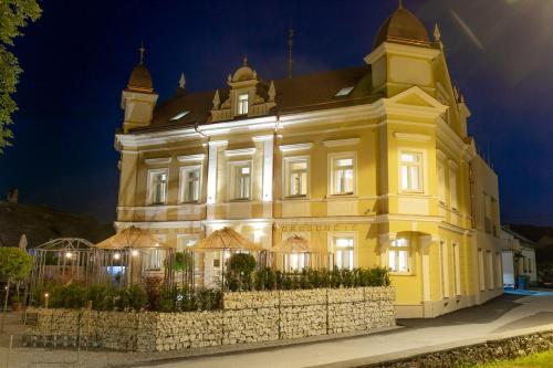 a large yellow building with a fence in front of it at Dvorec Gregorčič in Smarjeske Toplice