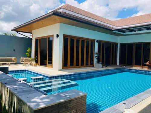 a swimming pool in front of a house at Banburi Villa - 5 Bedroom Private Pool Villa in Krabi