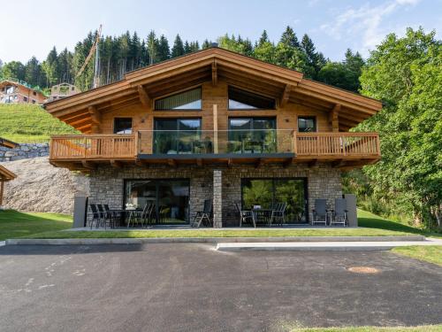 a large wooden house with a deck on top at Semi detached chalet in M hlbach with sauna in Mühlbach am Hochkönig