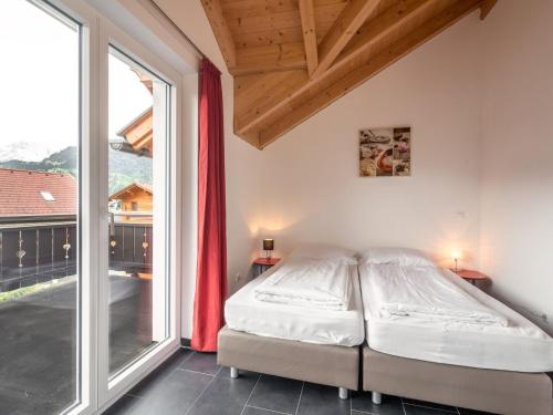 a bedroom with a bed and a large window at Chalet in Carinthia near ski area in Kötschach