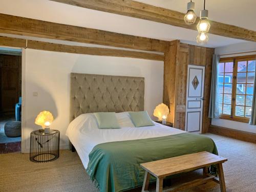 a bedroom with a large bed in a room with wooden walls at L'Ecole des Demoiselles in Honfleur