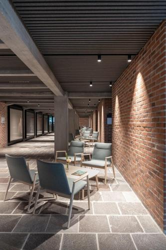 a room with chairs and tables and a brick wall at Cusanus Akademie - Accademia Cusanus in Bressanone