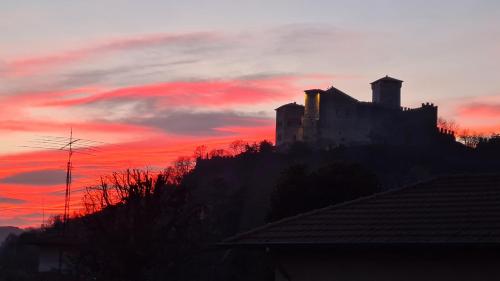 a castle on top of a hill at sunset at Dragonfly Appartamento Blu in Angera