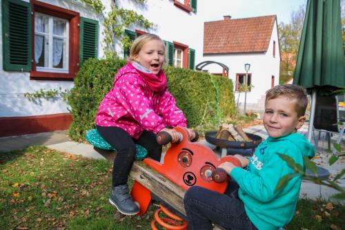 Un ragazzo e una ragazza seduti su un treno giocattolo di Ferienbauernhof Moarhof a Wittelshofen