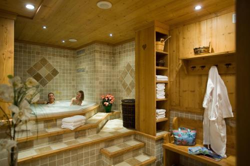 two people in a bath tub in a bathroom at Studio Danay Accès Espace Détente Gratuit in Le Grand-Bornand