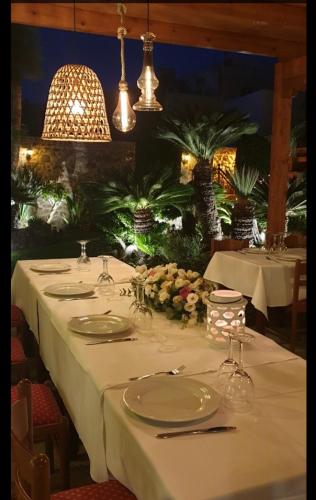 a table with white tablecloths and plates on it at Paris Hotel in Rhodes Town
