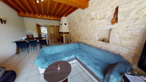 een woonkamer met een blauwe bank en een tafel bij L'Horizon in La Burbanche