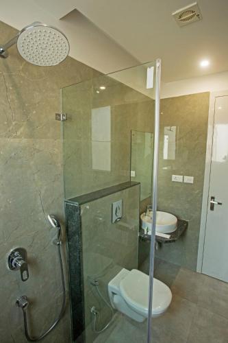 a bathroom with two sinks and a shower with a toilet at Grey House Inn in Guwahati
