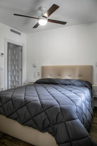 a bedroom with a bed with a ceiling fan at La Casa de Alarcón in Alarcón