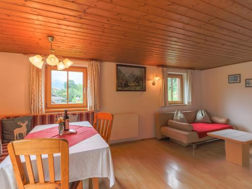 a living room with a table and a couch at Cosy holiday home near ski area in Piesendorf