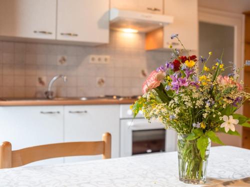 a vase of flowers sitting on a table in a kitchen at Apartment in Tr polach Carinthia with pool in Tröpolach