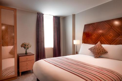 a hotel room with a bed and a window at PREMIER SUITES Manchester in Manchester