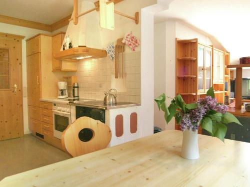una cocina con una mesa de madera y un jarrón de flores en Apartment in Huettschlag near the ski slopes, en Karteis